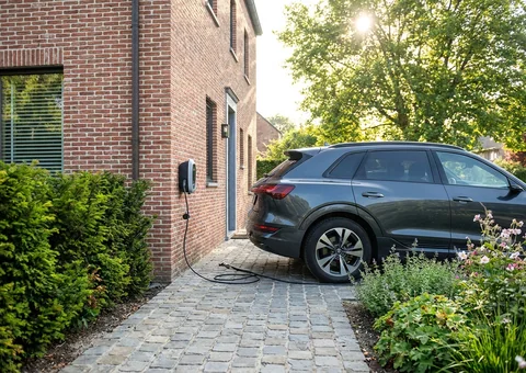Elektrische wagen die oplaadt aan een laadpaal op een oprit